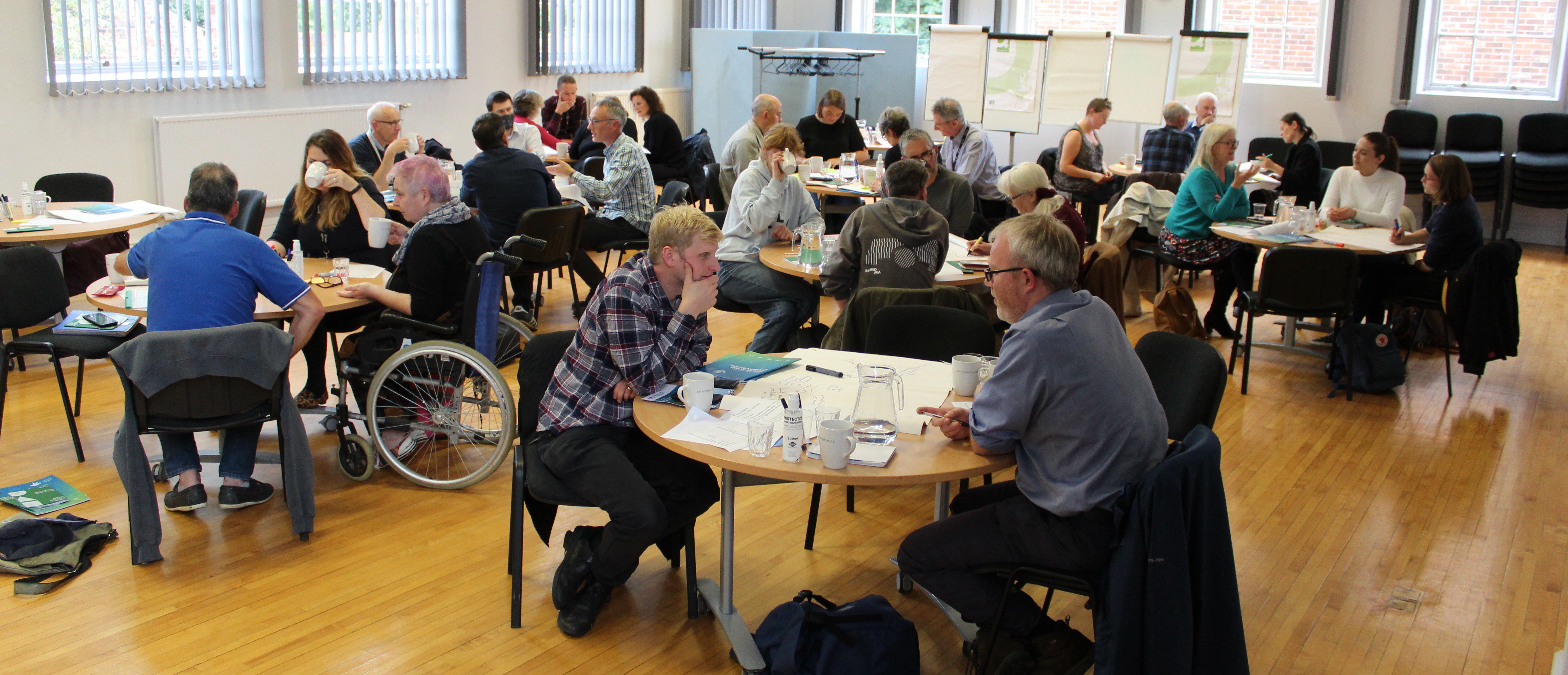 IMG_0207 People sitting around tables in a hall having discussions